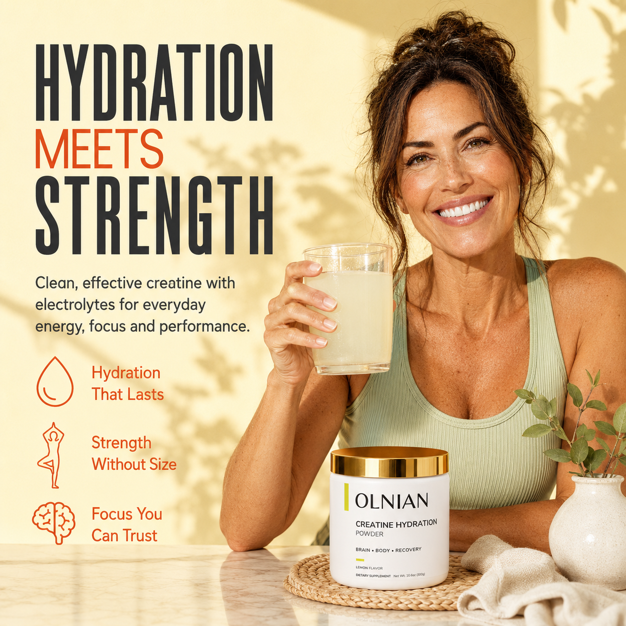 A smiling woman in a ribbed tank top holds a glass of pale yellow drink beside a tub of Iolnian Creatine Hydration Powder on a table, with large marketing text reading 'Hydration Meets Strength' on a warm beige background.