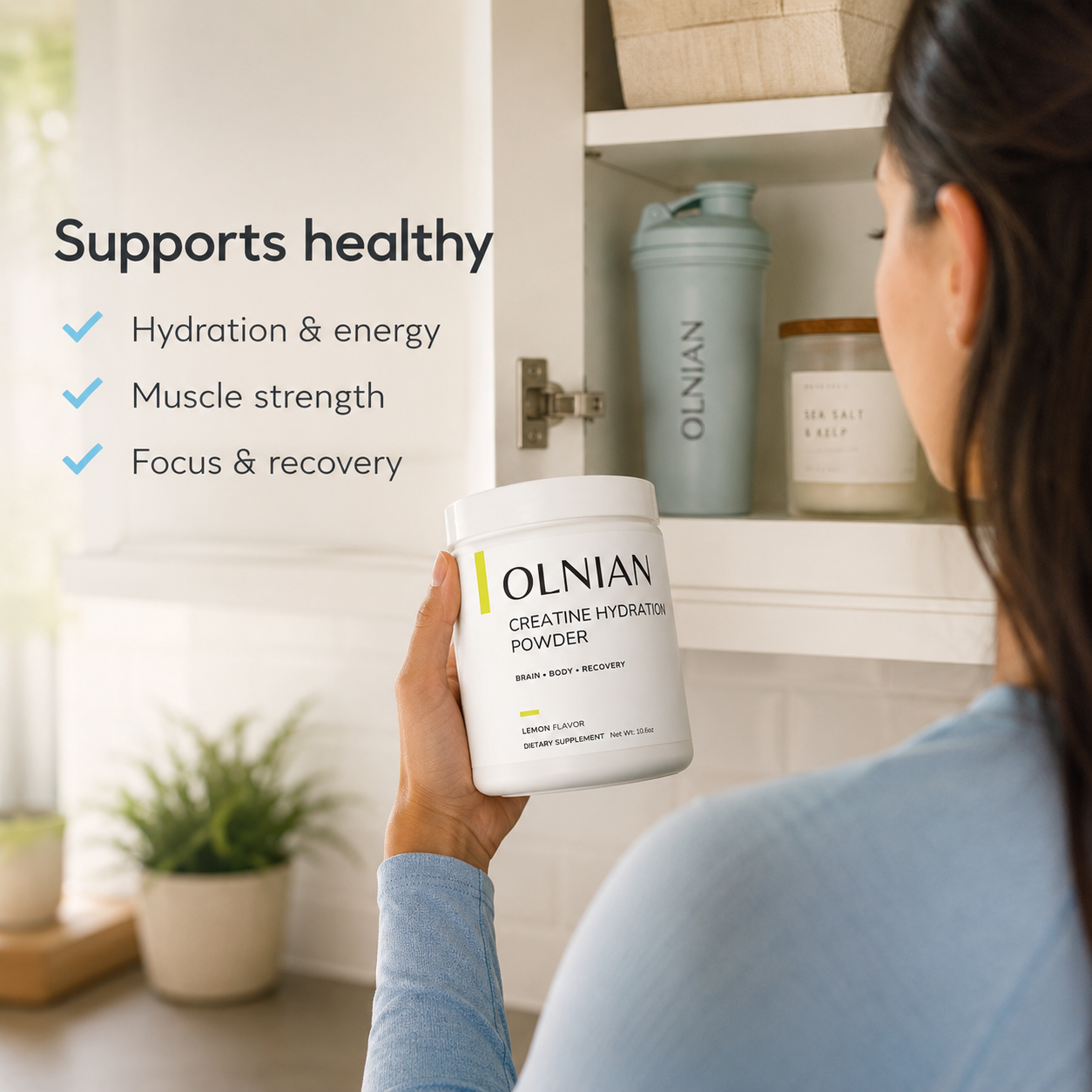 A woman in a blue top holds a white tub of OLNIAN Creatine Hydration Powder in front of an open white cabinet. Text on the left reads 'Supports healthy' with bullet points about hydration, energy, muscle strength, and focus/recovery.