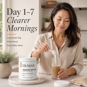 A woman in a beige blouse stands in a bright kitchen, adding powder from an OLNIAN tub into a glass of coffee. Large text on the left reads 'Day 1-7 Clearer Mornings' with supporting benefits.
